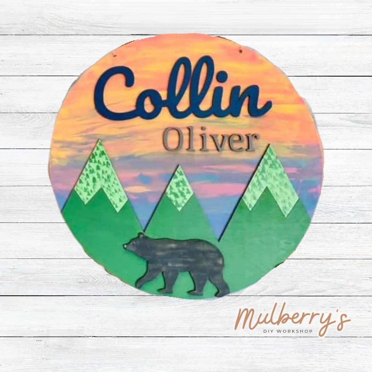 Bring the wilderness inside with our personalized 18-inch door hanger that features mountians and a bear.