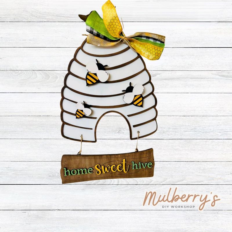 Our bee hive mini door hanger is bee-tastic! Approximately 10.5" tall by 10.5" wide.