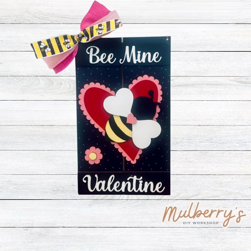 Decorate your front door for Valentine's Day with our Bee Mine Valentine mini door hanger! Approximately 12" tall by 8" wide.