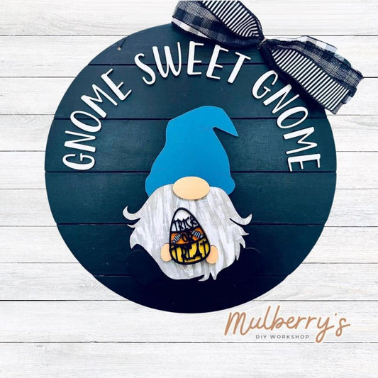 This sweet little fella will make you smile each season and holiday. Simply swap out his hands to create a brand new door hanger! The door hanger is approximately 18-inches in diameter and comes with or without greenery on the backer. Includes Gnome Sweet Gnome door hanger with halloween insert.