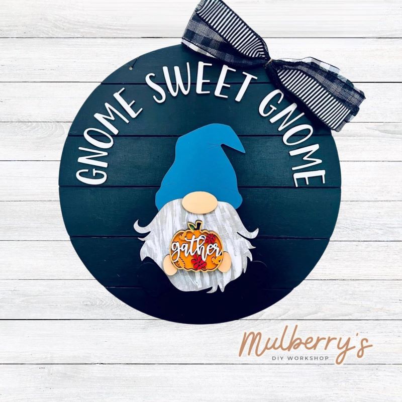 This sweet little fella will make you smile each season and holiday. Simply swap out his hands to create a brand new door hanger! The door hanger is approximately 18-inches in diameter and comes with or without greenery on the backer. Includes Gnome Sweet Gnome door hanger with fall insert.