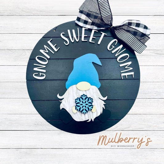 This sweet little fella will make you smile each season and holiday. Simply swap out his hands to create a brand new door hanger! The door hanger is approximately 18-inches in diameter and comes with or without greenery on the backer. Includes Gnome Sweet Gnome door hanger with winter insert.