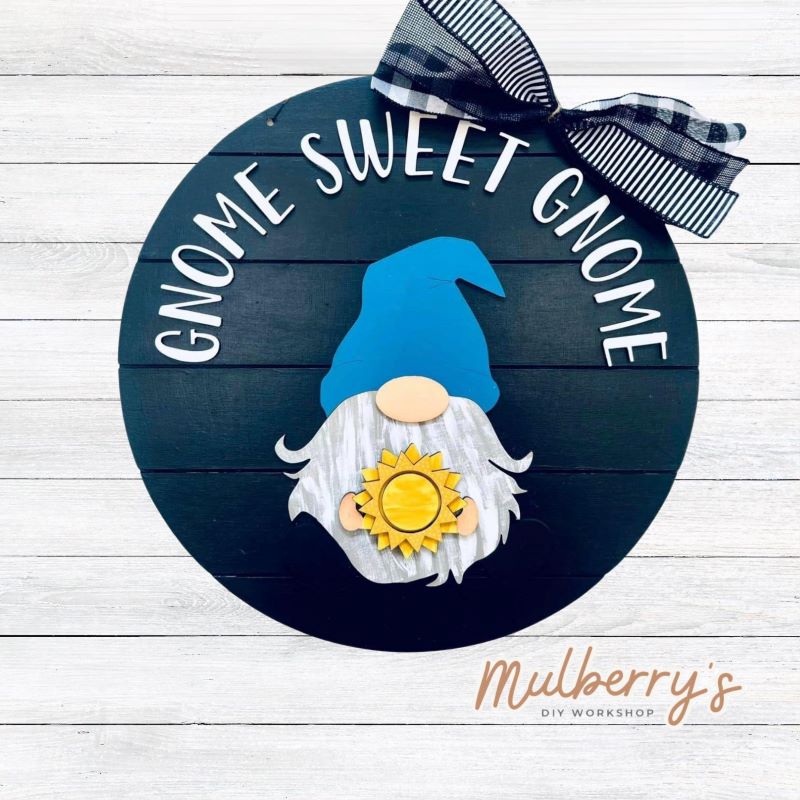 This sweet little fella will make you smile each season and holiday. Simply swap out his hands to create a brand new door hanger! The door hanger is approximately 18-inches in diameter and comes with or without greenery on the backer. Includes Gnome Sweet Gnome door hanger with summer insert.