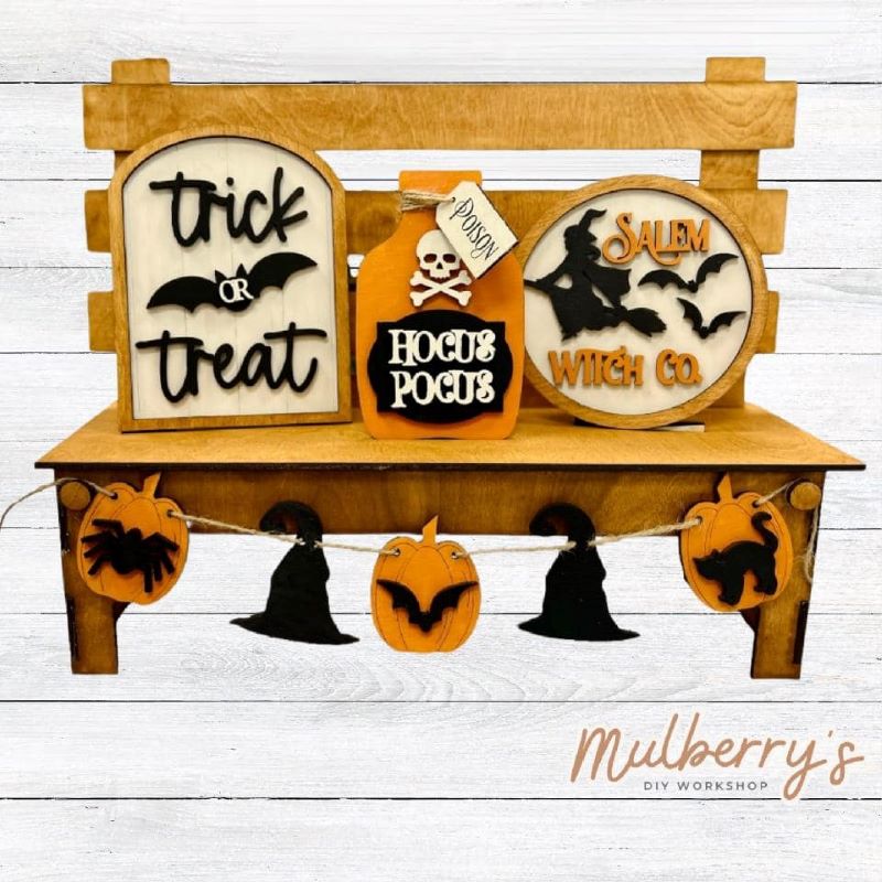 It doesn't get any cuter than our interchangeable bench! It's a perfect add on accessory to your décor. It's approximately 14" tall x 17" wide.  Includes: Bench and Halloween Inserts. Halloween inserts include trick or treat sign, hocus pocus potion jar, Salem Witch Co. sign, and pumpkin/witch hat banner.