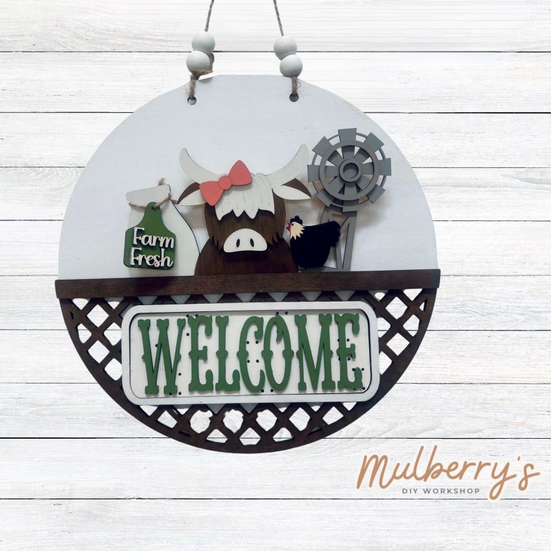 Welcome family and friends with our interchangeable lattice round door hanger! Simply swap out inserts to match the different holidays and seasons! It's approximately 10.5" in diameter.  Includes: Lattice Round Door Hanger with Highland Cow Inserts. Additional inserts are available to purchase.