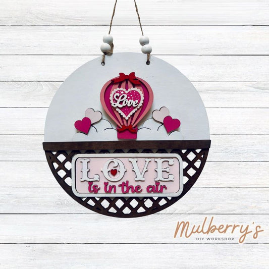 Welcome family and friends with our interchangeable lattice round door hanger! Simply swap out inserts to match the different holidays and seasons! It's approximately 10.5" in diameter.  Includes: Lattice Round Door Hanger with Valentine Hot Air Ballon Inserts. Additional inserts are available to purchase.