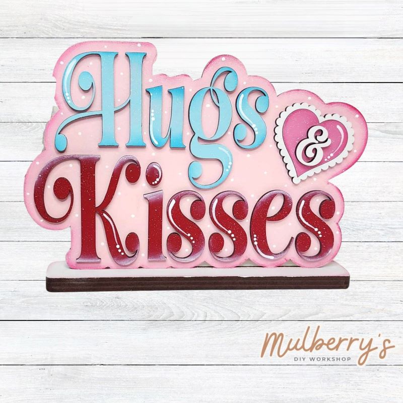 Our Hugs & Kisses shelf sitter is the perfect addition to your Valentine decor! Approximately 9" wide by 6" tall. Includes stand.