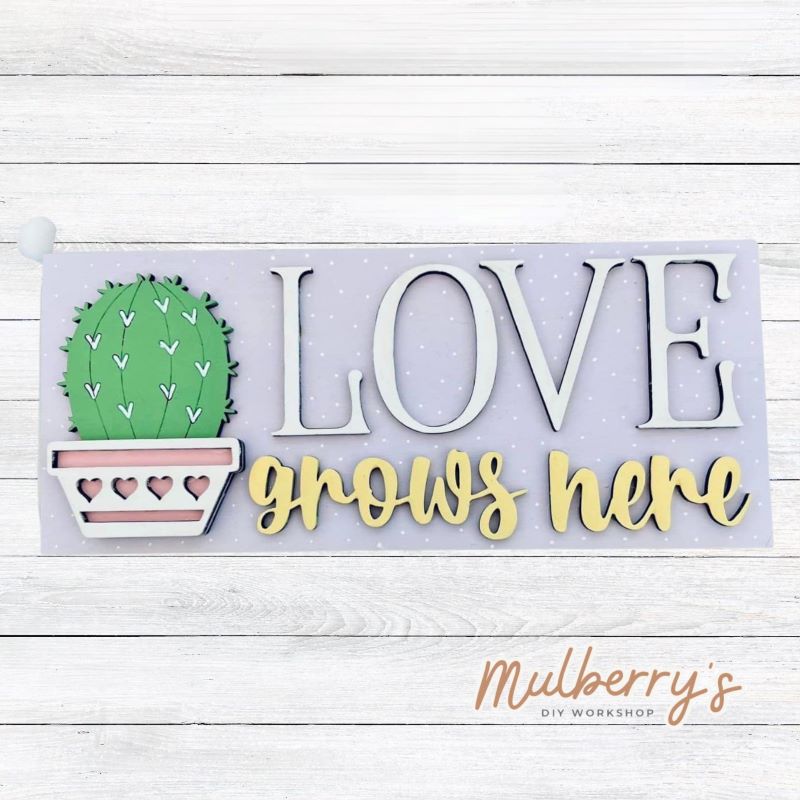 Love grows in your home! Come decorate our love grows here mini sign! Approximately 4" tall by 9.5" wide.