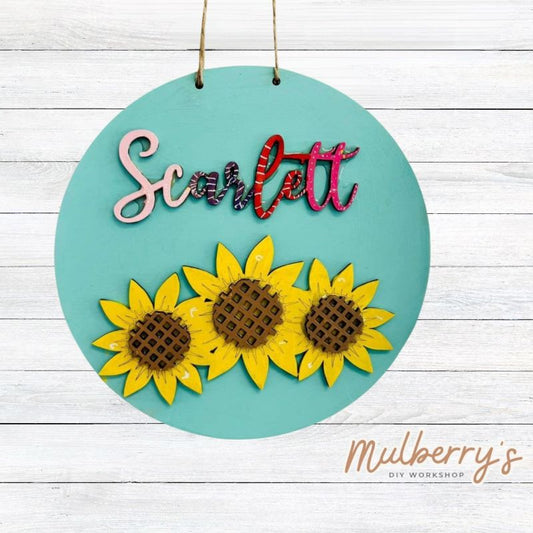 Our mini 9.5" door hanger with a sunflower and is a popular project for kids! This design can be personalized with a name in either print or cursive.