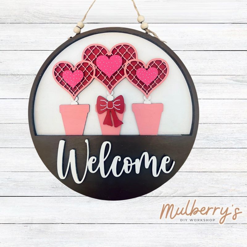 Welcome family and friends with our interchangeable welcome door hanger! Simply swap out inserts to match the different holidays and seasons! It's approximately 10.5" in diameter.  Includes: Welcome Door Hanger with Valentine Flowers Insert. Additional inserts are available to purchase.