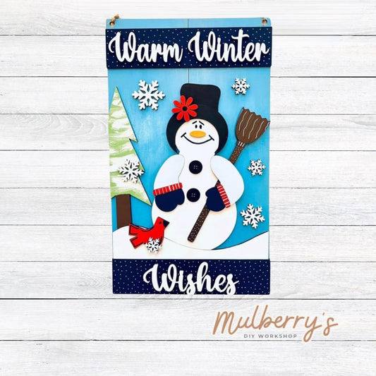 Warm up your home with our warm winter wishes snowman mini door hanger! Approximately 14" tall by 8" wide.