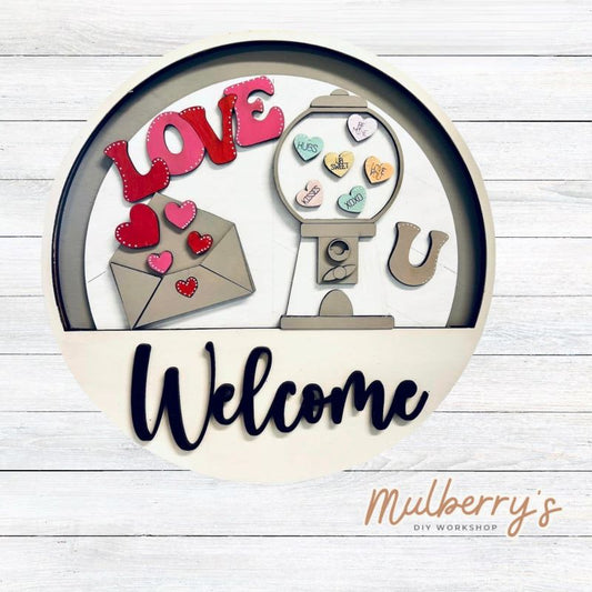 Welcome family and friends with our interchangeable welcome door hanger! Simply swap out inserts to match the different holidays and seasons! It's approximately 10.5" in diameter.  Includes: Welcome Door Hanger with Valentine Gumball Insert. Additional inserts are available to purchase.