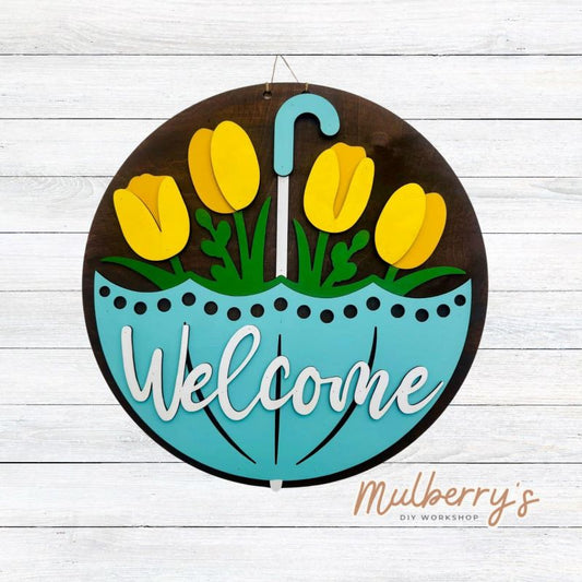 Welcome Spring into your home with this quirky 18 inch door hanger featuring a gigantic umbrella with tulips peeping from the inside.&nbsp; Hang it on your front door to greet guests with a playful touch. Perfect for adding a unique touch to your seasonal decor.
